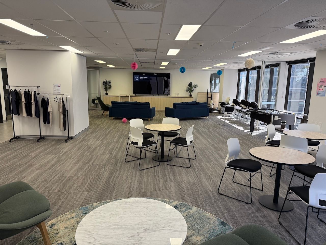 A presentation room with sofas, and chairs around table